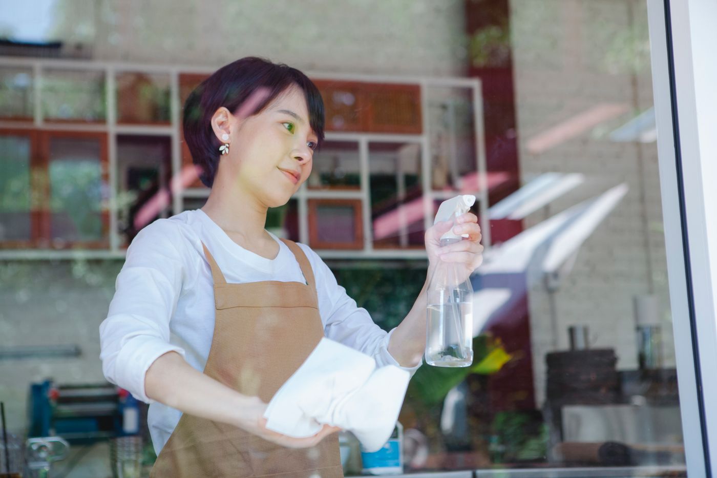 Facility professional carefully cleaning workplace glass